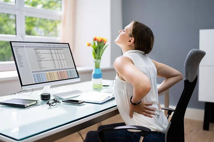 Woman sitting at desk with lower back pain