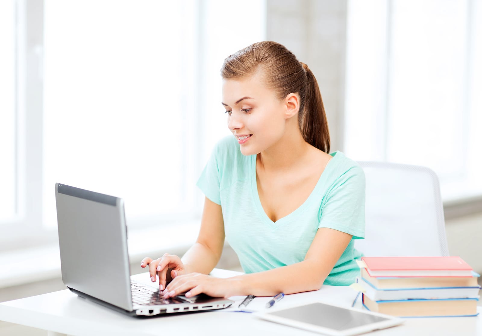 Women at desk typing on a laptop computer