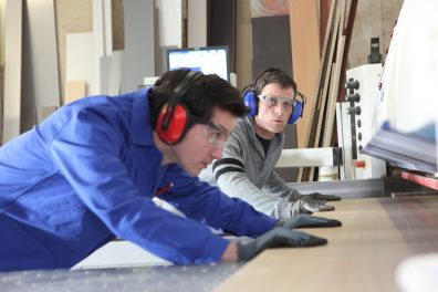 Carpenter and apprentice in workshop
