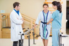 People Moving and Handling trainer assisting female patient